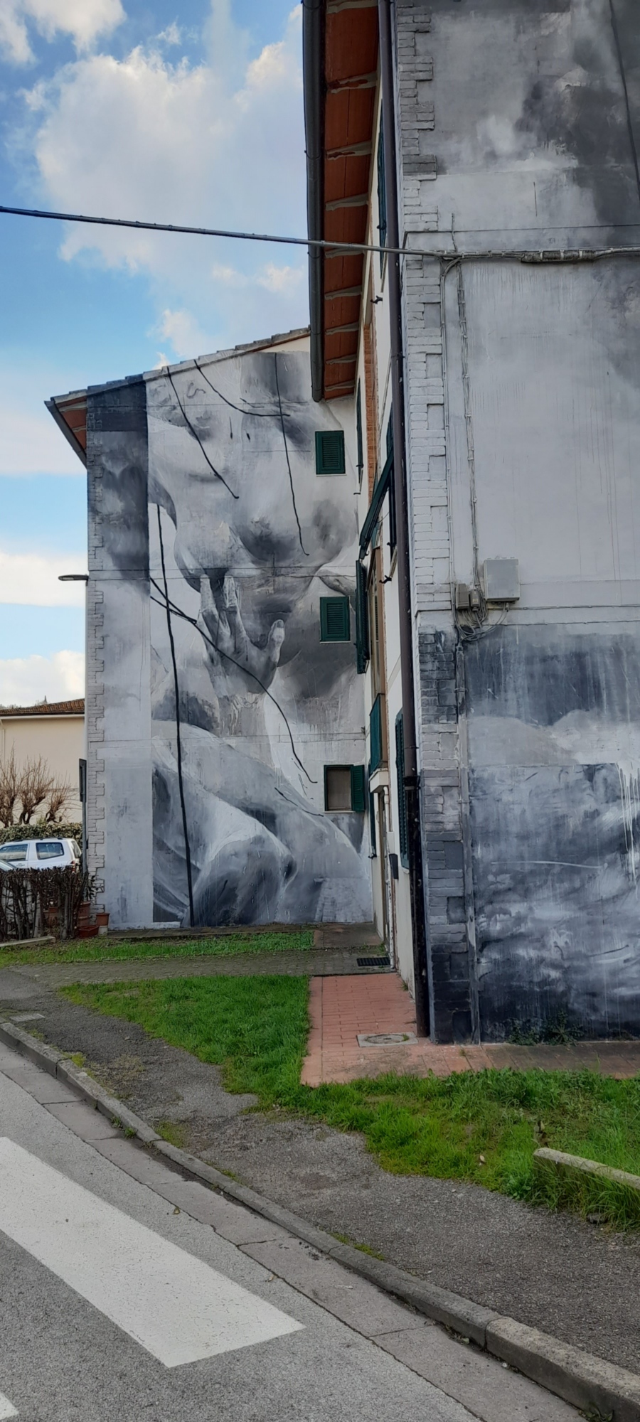 Des figures humaines en mouvement, difficiles à distinguer, les naufragés et les rescapés, sur les façades des maisons.