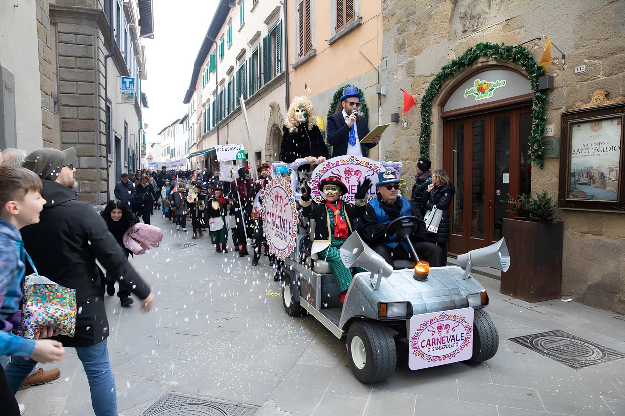 Image du défilé du carnaval de Sansepolcro avec, au premier plan, le masque typique du village