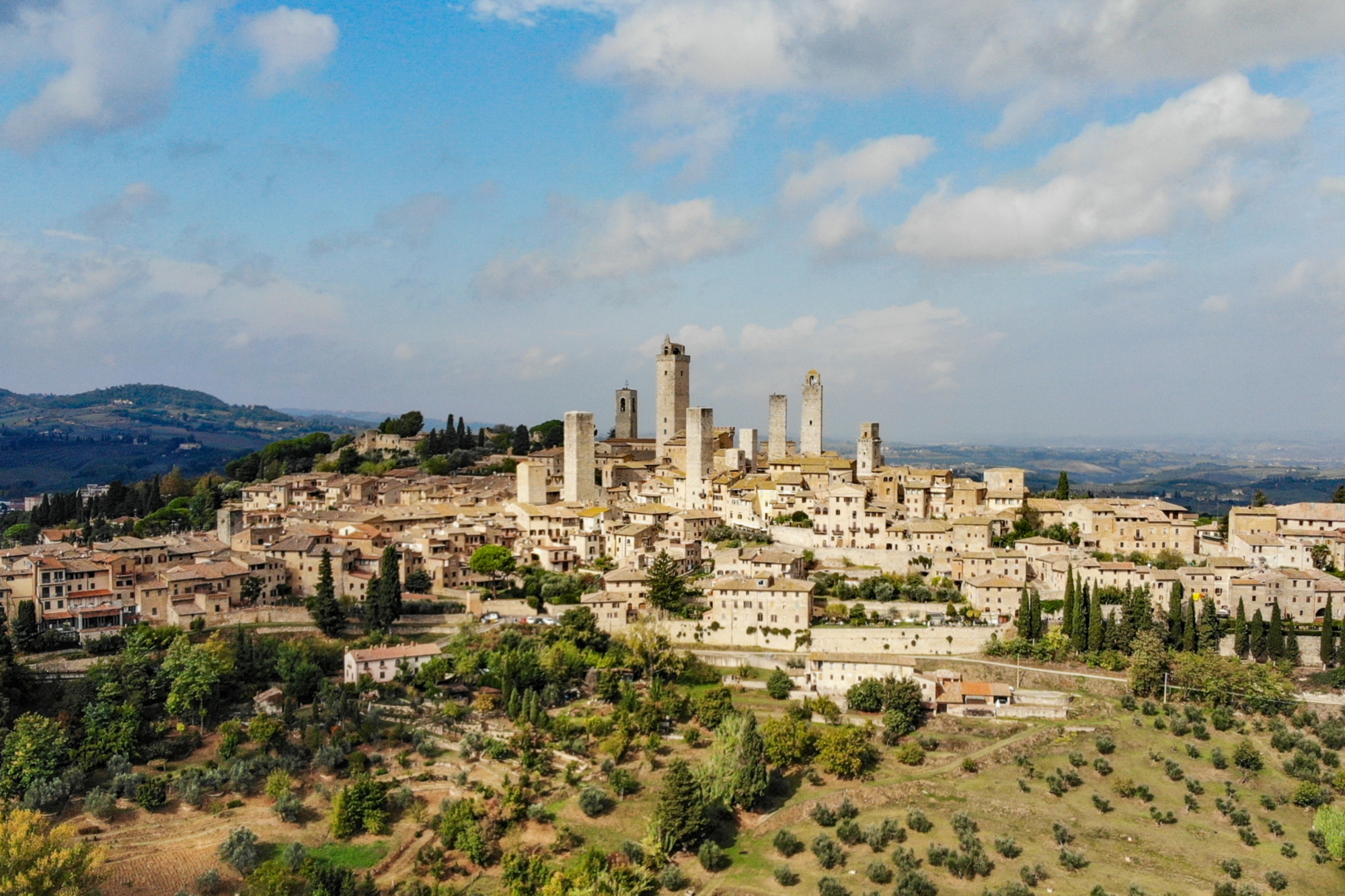 Vue panoramique de San Gimignano avec ses tours médiévales typiques s’élevant parmi les collines toscanes.