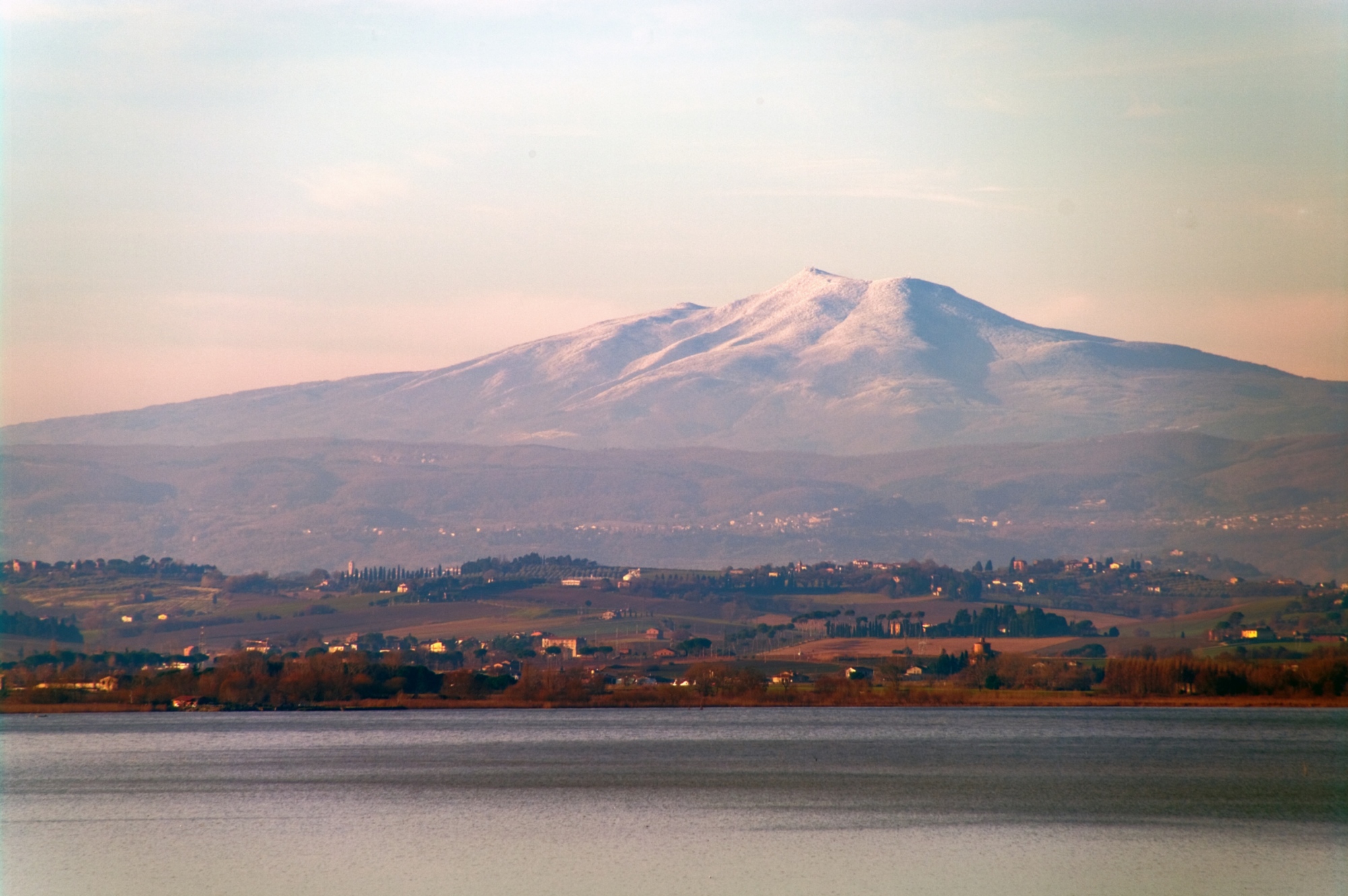 Vue panoramique sur le mont Amiata enneigé et les collines environnantes.