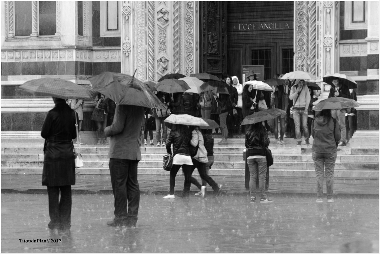 Journée pluvieuse à Florence, au premier plan des personnes avec des parapluies ouverts.